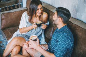 Erstes Date nach einem Match – zwei Menschen sitzen im Café und lachen gemeinsam